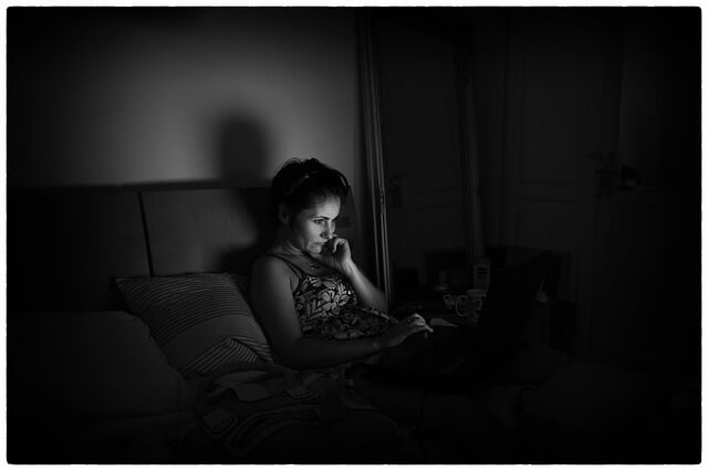 Mujer usando su ordenador por la noche en la cama